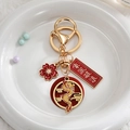 Porte-clés dragon chinois avec anneau doré et pendentifs en émail rouge sur peluche blanche - Braver les Vagues