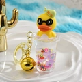 Close-up of yellow duck charm with purple bubble tea cup, gold bell and keychain - Milk Tea Cup Shape