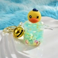 Close-up of yellow duck keychain with liquid, gold stars and large metal bell - Pressure Cooker Style
