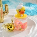 Detail of liquid-filled star charm with yellow cartoon duck and golden bell keychain - Big Belly Cup Style