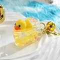 Detailed close-up of cartoon yellow duck keychain with golden bell and ring - Bathtub Style
