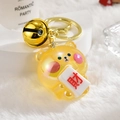 Dettaglio macro del portachiavi a forma di orso con ciondolo mahjong e campanella - Chiusura in Oro Chiaro + Orsetto della Fortuna + Campanello / Giallo Limone