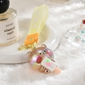 Détail d'un porte-clés ours en acrylique avec sangle en silicone jaune et glace fraise - Sangle d'ours + Ours Lumineux / Gris