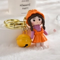 Dettaglio del portachiavi con bambolina carina, grande campanello giallo e gancio dorato - Fibbia Oro Chiaro + Ragazza + Campanello / Giallo Limone