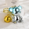 Macro detail of gradient blue and silver metallic bear charm with a golden bell - Blue & Silver