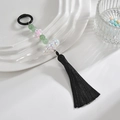 Makro-Detail des chinesischen Perlenquastens mit grünen Perlen und lila Blumenanhänger - Farbiger Ring + Kette + Quaste / Schwarz