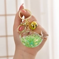Detail of whale keychain with green star glitter and golden bell accessory held by hand - Light Gold Buckle + Luminous Fish + Bell / Luminous Green