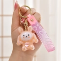 Detailed close-up of a pearlescent pink rabbit keychain with a translucent bubble wrist strap - Pink