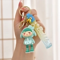 Detail of cute mint green doll keychain with golden bell and blue gradient lanyard - Gradient Strap + Girl + Bell / Green