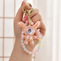 Dettaglio del portachiavi a forma di coniglio astronauta rosa perlato con perline e orso - Coniglio Luminoso + Catena con Perline / Rosa Pasta di Fagioli (Stile con Perline)