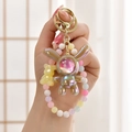 Macro shot of iridescent astronaut rabbit keychain with colorful beads and gold clasp - Light Coffee (Beaded Style)