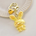 Close-up of yellow cartoon bunny keychain with LOVE engraving and golden bell charm - Light Gold Buckle + Rabbit + Bell / Lemon Yellow