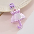 Macro detail of a purple UV coated umbrella keychain with heart and wing charms - Purple