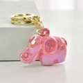 Macro-opname van de roze olifanthanger met iriserende coating en goudkleurige sleutelhanger - Roze