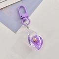 Detail of purple acrylic conch keychain with embedded natural seashells and sequins - Purple