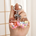 Nahaufnahme von flüssigem Glitzer Schlüsselanhänger mit Perlen und Schleifen-Anhänger - Silberschnalle + Schleife + Glocke / Rosa
