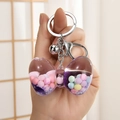 Nahaufnahme eines Schleifen-Schlüsselanhängers mit bunten Perlen und violettem Glitzer - Silberschnalle + Schleife + Glocke / Lila