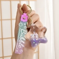 Detail van sterrenvormige glitter sleutelhanger met paarse eenhoorn en parels - Paars