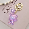 Porte-clés ours acrylique irisé violet avec boule étoilée sur un livre décoratif - Violet