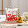 Detailed macro view of liquid quicksand acrylic keychain with white cartoon figure and gold bell - Donut Pillow Style / Red