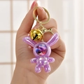 Purple iridescent space bunny keychain with a gold bell and metallic carabiner clip - Purple (Bell Style)