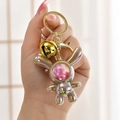 Iridescent astronaut rabbit keychain with pink star patterns and a gold bell - Light Coffee (Bell Style)