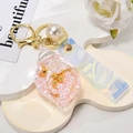 Detail of shell-shaped liquid keychain with pink pearls and laser strap accessory - Leather Strap + Small Conch + Pearl / Dusty Pink