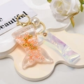 Detailed macro of a mermaid tail keychain with pink liquid sand and floating pearls - Shiny Cord + Mermaid + Pearl / Orange
