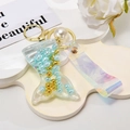 Macro shot of liquid quicksand mermaid tail pendant with pearls and colorful wrist strap - Shiny Cord + Mermaid + Pearl / Blue