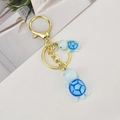 Détails de pendentifs tortue en résine bleue sur un porte-clés doré avec textures - Chaîne Or Clair + Grandes & Petites Tortues / Bleu
