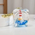 Acryl-Treibsand-Schlüsselanhänger mit maritimem Leuchtturm in blauer Flüssigkeit und Goldring - Wecker