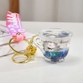 Detail of liquid quicksand cup keychain with cartoon fox and glitter in purple liquid - Gray Tea Cup Style