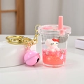 Detail of pink liquid kitty keychain with glitter sequins and gold bell accessory - Cartoon Cat Milk Tea Cup