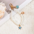 Detail of nautical pearl keychain with blue enamel starfish and shell charms - Ocean Blue Style