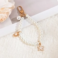 Elegant pearl chain keychain with gold starfish and shell pendants on plush background - White Starfish Pearl
