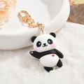 Detail of cute panda keychain with red heart and gold clasp on soft white fur backdrop - Panda With Red Heart