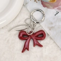 Elegante rode acryl strik hanger met zilveren veersluiting op witte pluche achtergrond - Bordeauxrood