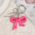 Pink bow pendant with silver metal ring on soft white plush background for bag and phone - Rose Red