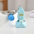 Blue feather resin keychain with Free engraving, bell accessory, and floral base details - Blue Free