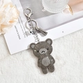 Vue détaillée du porte-clés ours en strass gris avec pompon et petite clochette - Gris