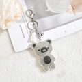 Portachiavi orso con strass scintillanti, nappa bianca e campanellino argento su fondo morbido - Bianco