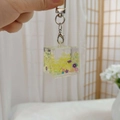 Détail du porte-clés à sable mouvant avec fleurs mauves et fermoir mousqueton argent - Fermoir Homard + Cube Lumineux / Jaune Citron
