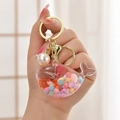 Pink whale liquid quicksand keychain with macaron beads and a gold metal ring - Jelly Bean Pink