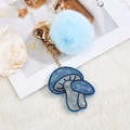 Detail of blue faux fur pompom and sparkling mushroom keychain with gold lobster clasp - Fur Ball Style / Blue