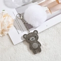 Close-up of cute white pompom and sparkling dark grey rhinestone bear keychain charm - Gray