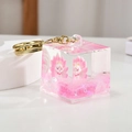 Pink quicksand cube keychain featuring a cartoon nine-tailed fox with a gold metal clasp - Pink Cube Style