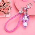 Portachiavi orsetto viola cangiante con cinturino in strass rosa su sfondo floreale - Viola