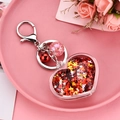 Gros plan du porte-clés cœur avec paillettes rouges, étoiles dorées et petite cloche rouge - Rouge