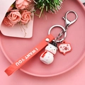 Detalle de un lindo llavero de muñeco de nieve con bufanda roja sobre fondo rosa - Muñeco de Nieve Lindo
