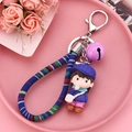 Detail of cute resin girl figurine keychain with colorful braided rope and purple bell - Dark Purple